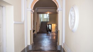 A hallway with a staircase leading to an upper floor. The walls are painted in a light color, and there is a decorative molding at the top of the walls. - Boutique Apartments Vienna (Vienna)