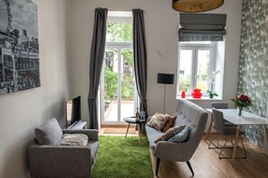 Lägenhet Design - 1 sovrum - uteplats - trädgård | Vardagsrum | 50-tums platt-tv med kabelkanaler, tv och kontor