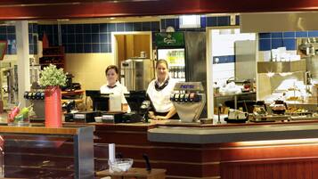 A commercial kitchen with a counter, a refrigerator, and various cooking equipment.
