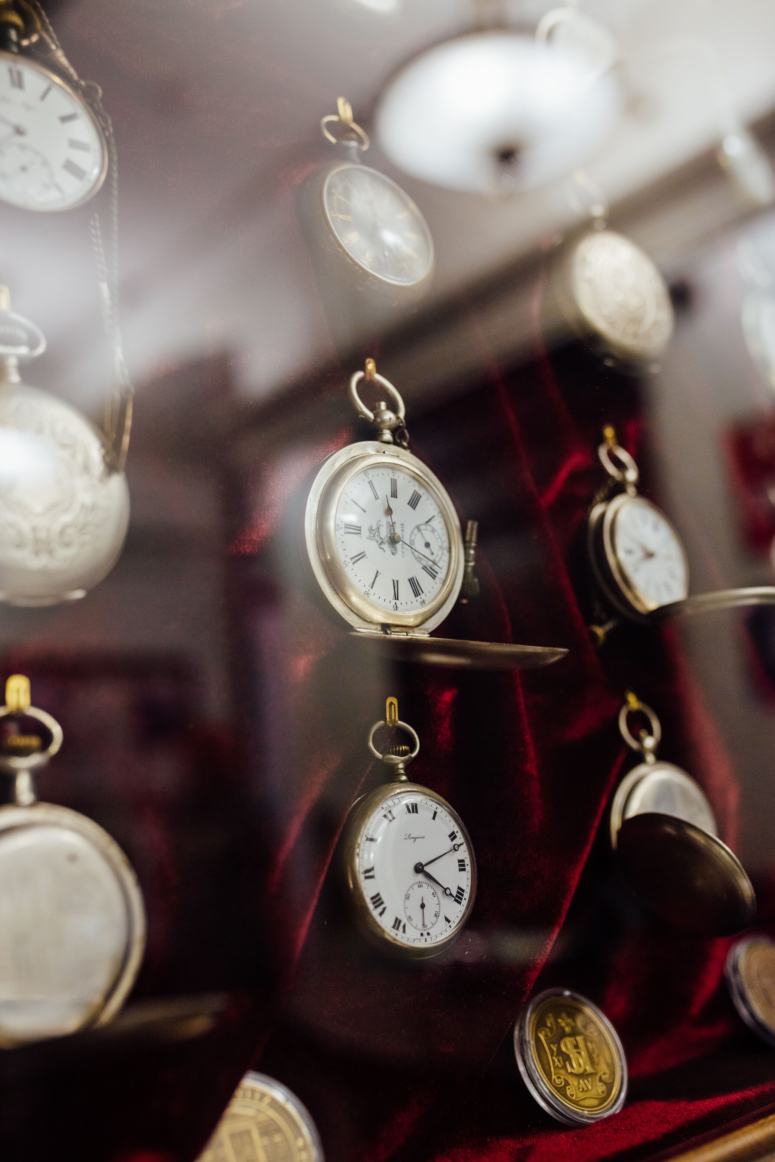 A collection of pocket watches displayed on a velvet-covered surface.