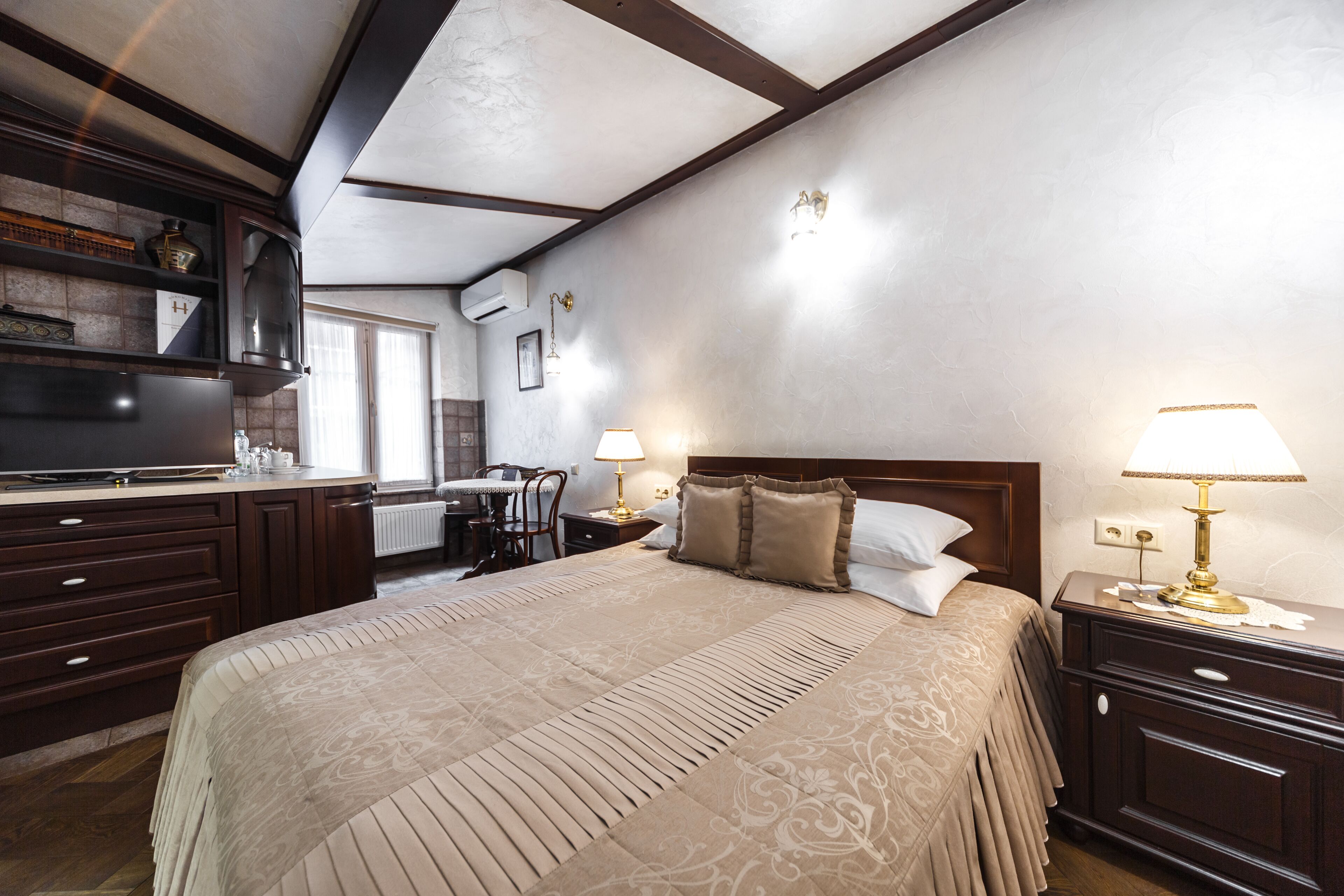 Una habitación de hotel con una cama grande, un escritorio y una kitchenette.