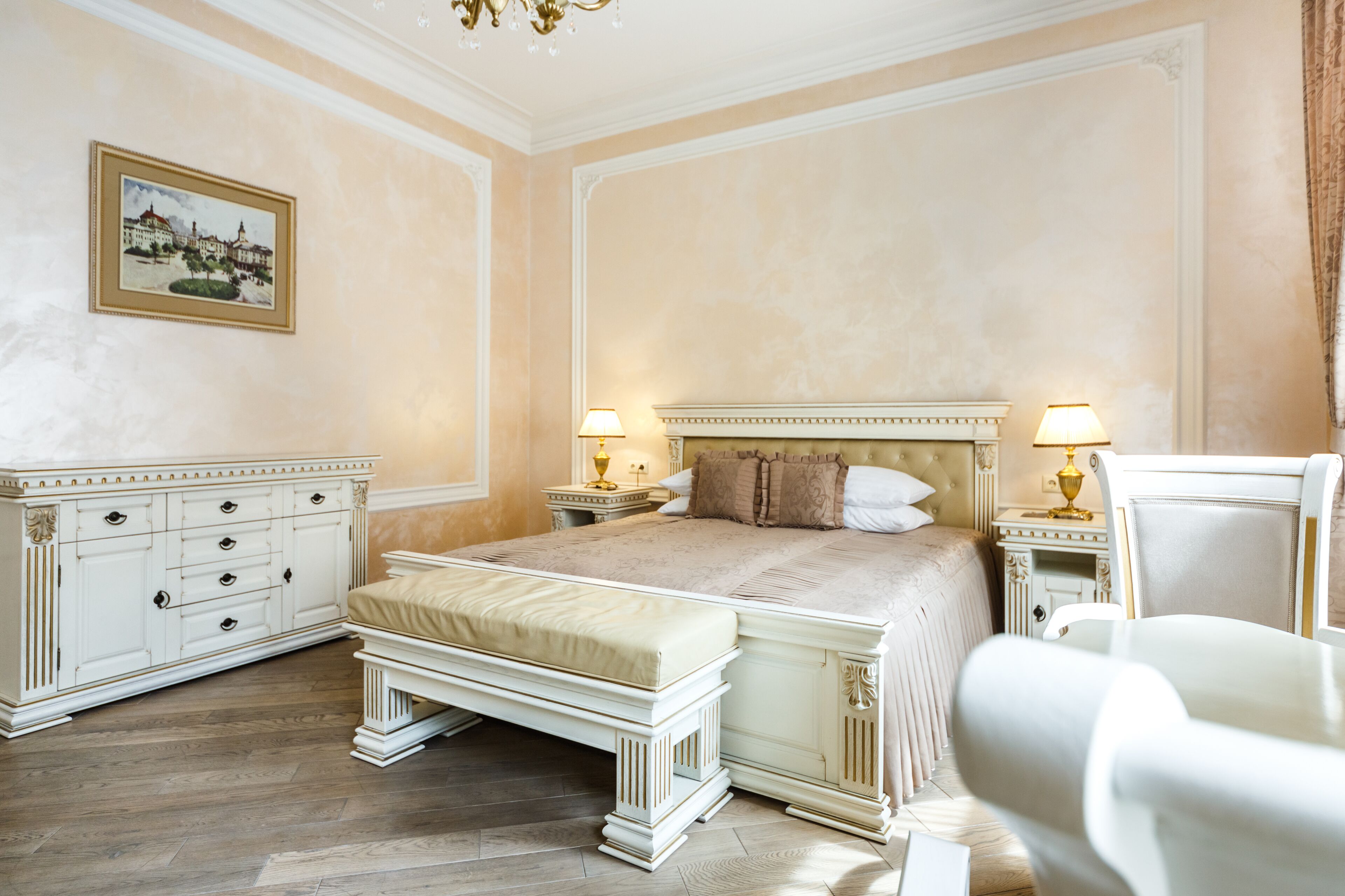 Un'ampia camera da letto con un letto grande, un comodino, una cassettiera e una sedia.