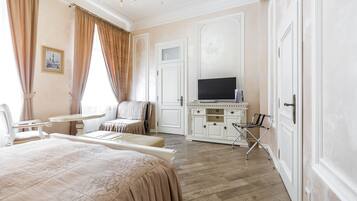Une chambre d’hôtel avec un grand lit, un bureau, une télévision et une chaise.