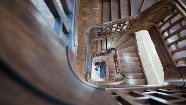 A spiral staircase with wooden steps and metal railings. - Apart-hotel Horowitz (Lviv)