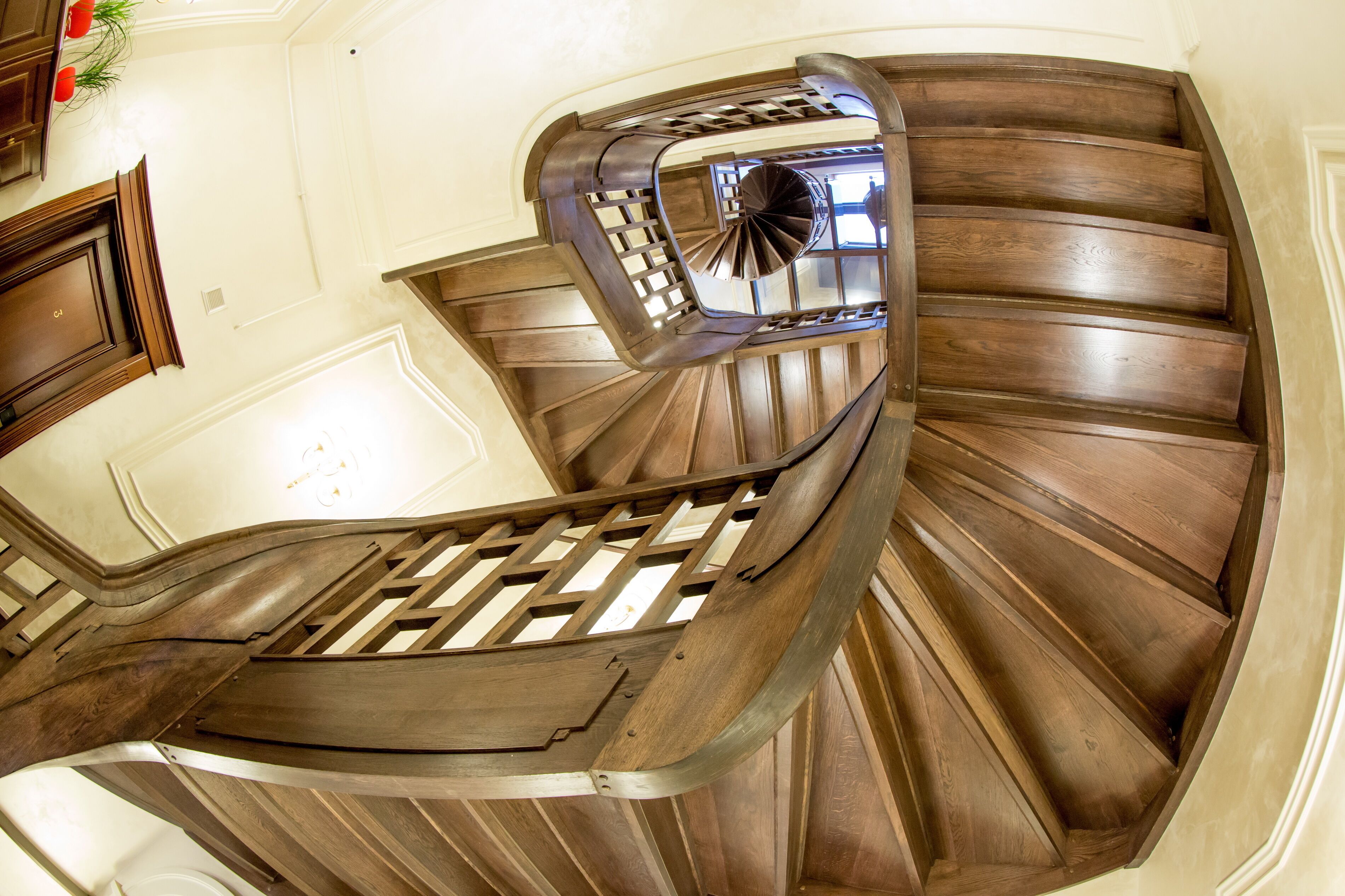 Una escalera de caracol con escalones de madera y barandilla de metal.