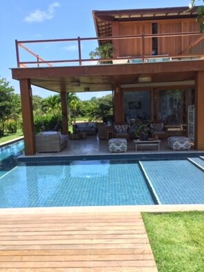 Alberca al aire libre y camastros 