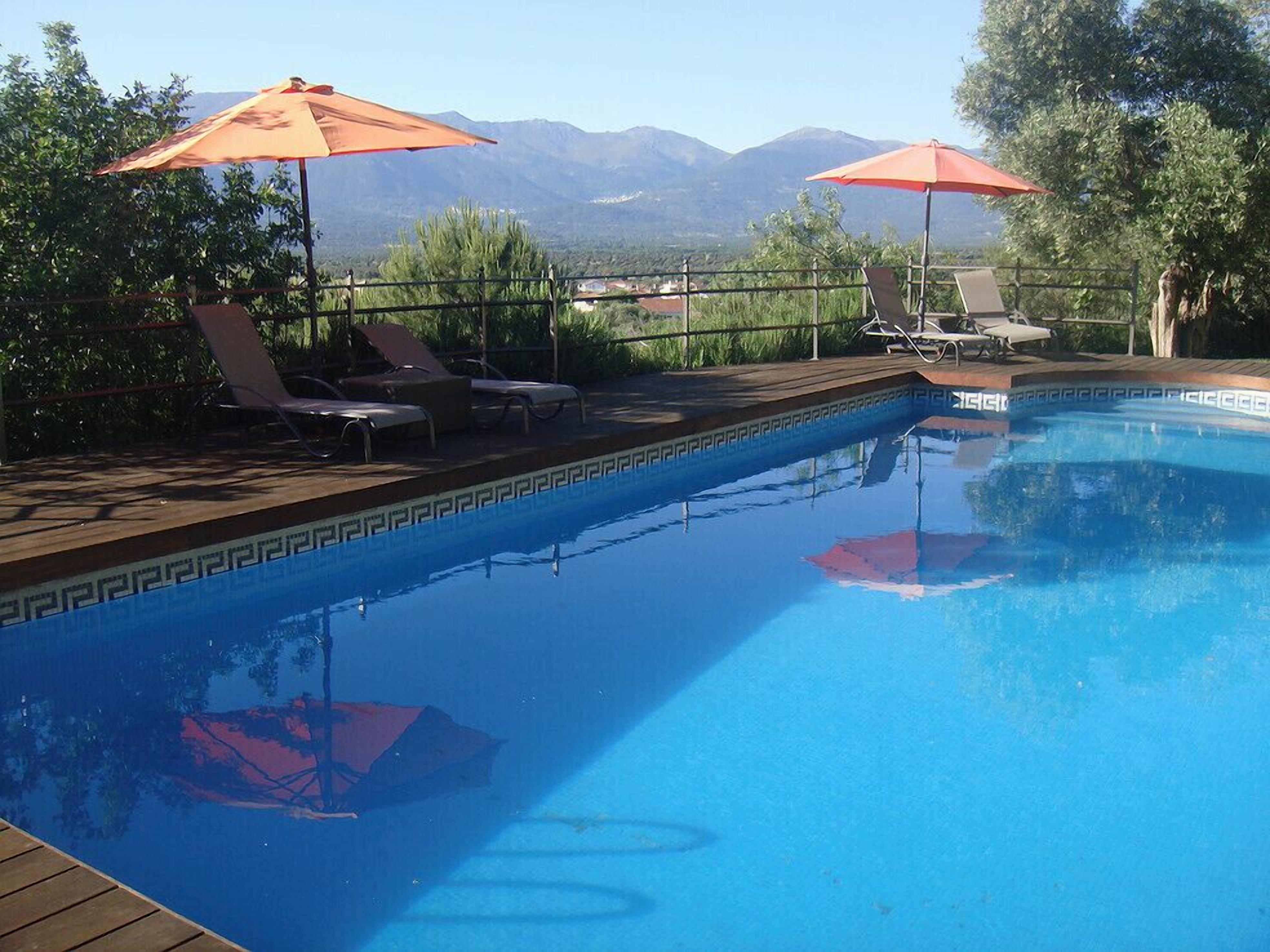Een buitenzwembad, parasols voor strand/zwembad