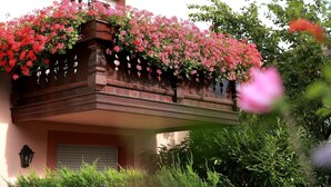 A building with a balcony covered in pink flowers. - Hôtel les Portes de la Vallée (Turckheim)