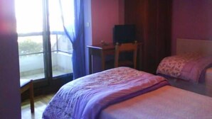 A bedroom with two beds, a desk, and a chair. - Hotel Solpor (Vigo)