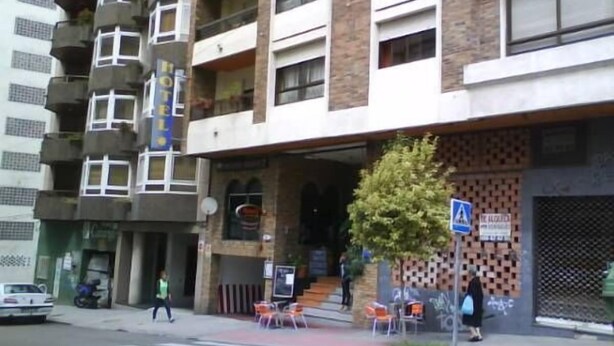 A hotel with a ground floor entrance, outdoor seating, and a visible staircase leading to the entrance. - Hotel Solpor (Vigo)