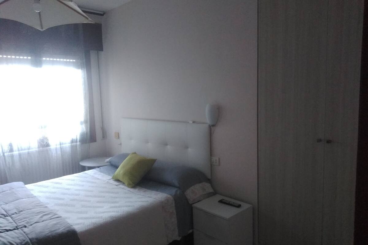 A bedroom with a bed, bedside table, and a nightstand.