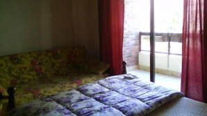 A room with a bed, a sofa, and a window with red curtains. - Hotel Solpor (Vigo)