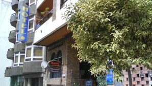 A hotel with a brick facade, multiple balconies, and outdoor seating. - Hotel Solpor (Vigo)