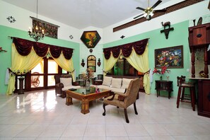 A spacious living room with a sofa, armchairs, a coffee table, and a chandelier. - Mariposa (Sosúa)