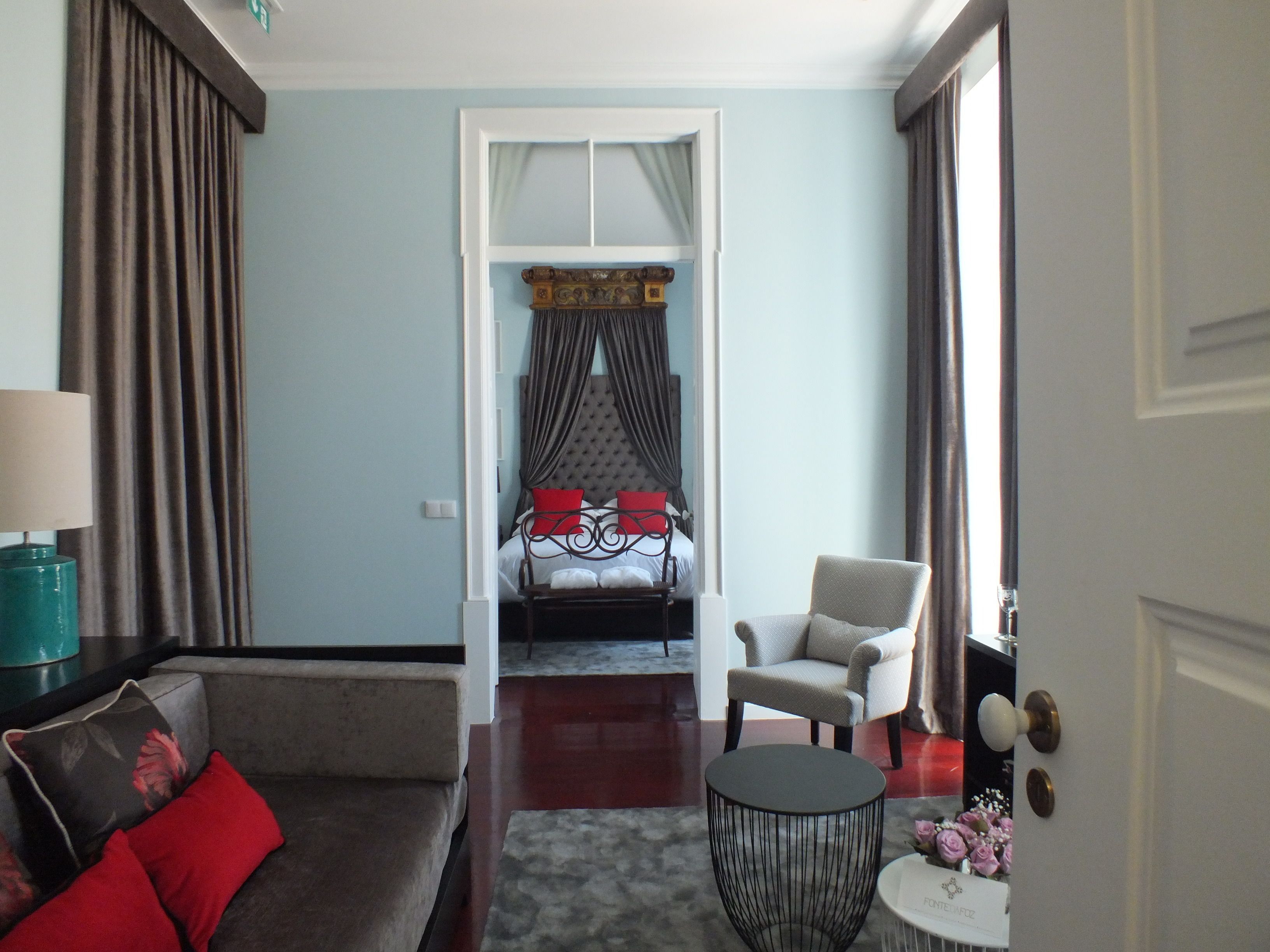 Une chambre d’hôtel avec un lit, un canapé, une chaise et une petite table.