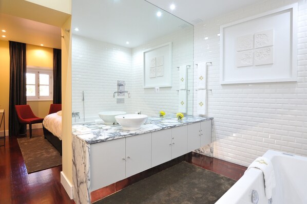 A modern bathroom with a large mirror, two sinks, a bathtub, and a red chair. - Fonte da Foz Bed & Breakfast Terrace (Figueira da Foz)