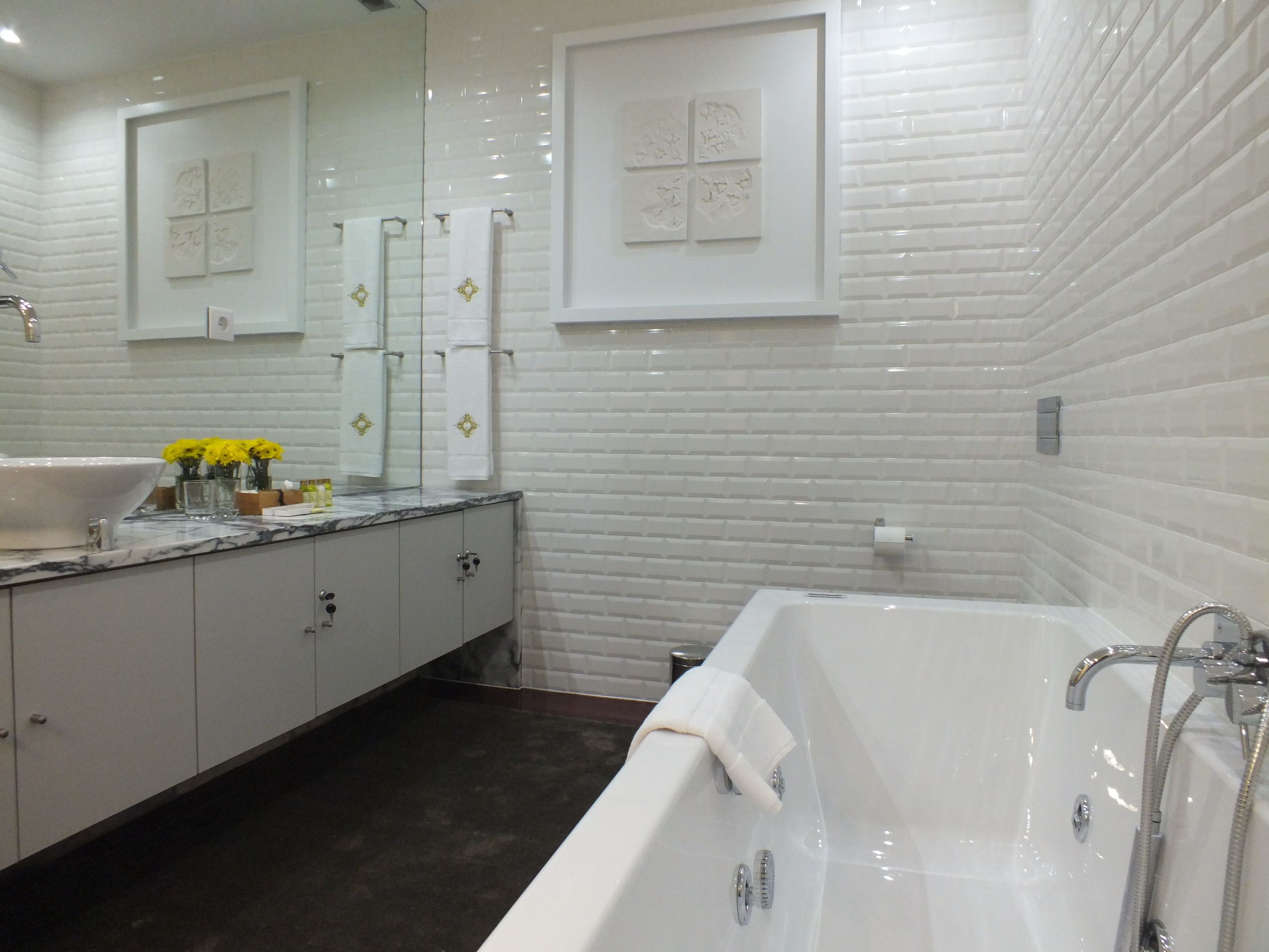 A modern bathroom with a large bathtub, a vanity with a sink, and a mirror.