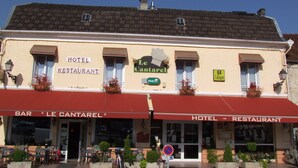 Um edifício com placa indicando que é um hotel e restaurante.
