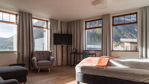 Une chambre d’hôtel avec un lit, un bureau, une chaise et un téléviseur.