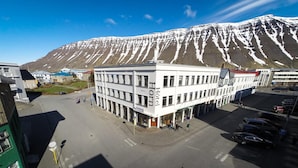 Un hôtel au design moderne, situé dans un parking avec une montagne en toile de fond.