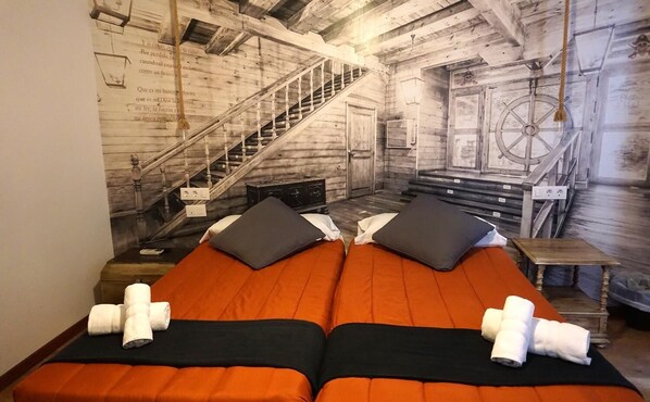 Una habitación con dos camas, una escalera y decoración temática náutica.