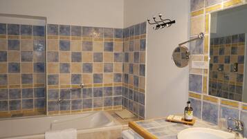 A bathroom with a bathtub, a sink, and a mirror.