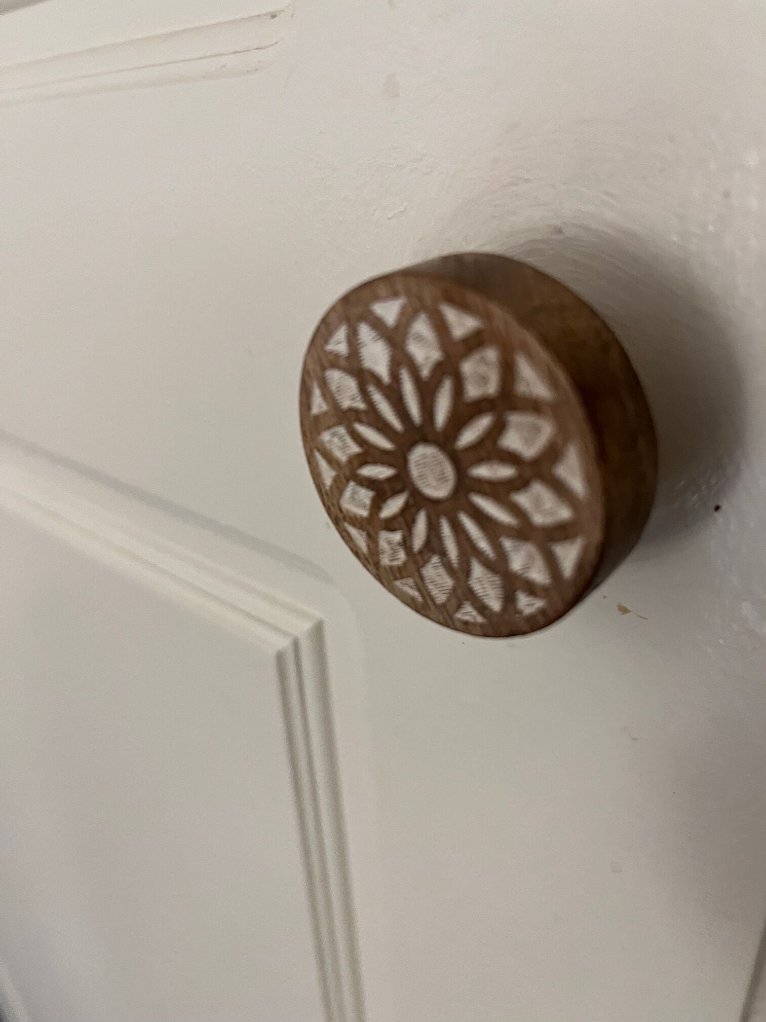 Une porte blanche ornée d’une poignée ronde et dotée d’un motif complexe.