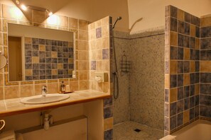 Un baño con lavamanos, espejo y ducha.