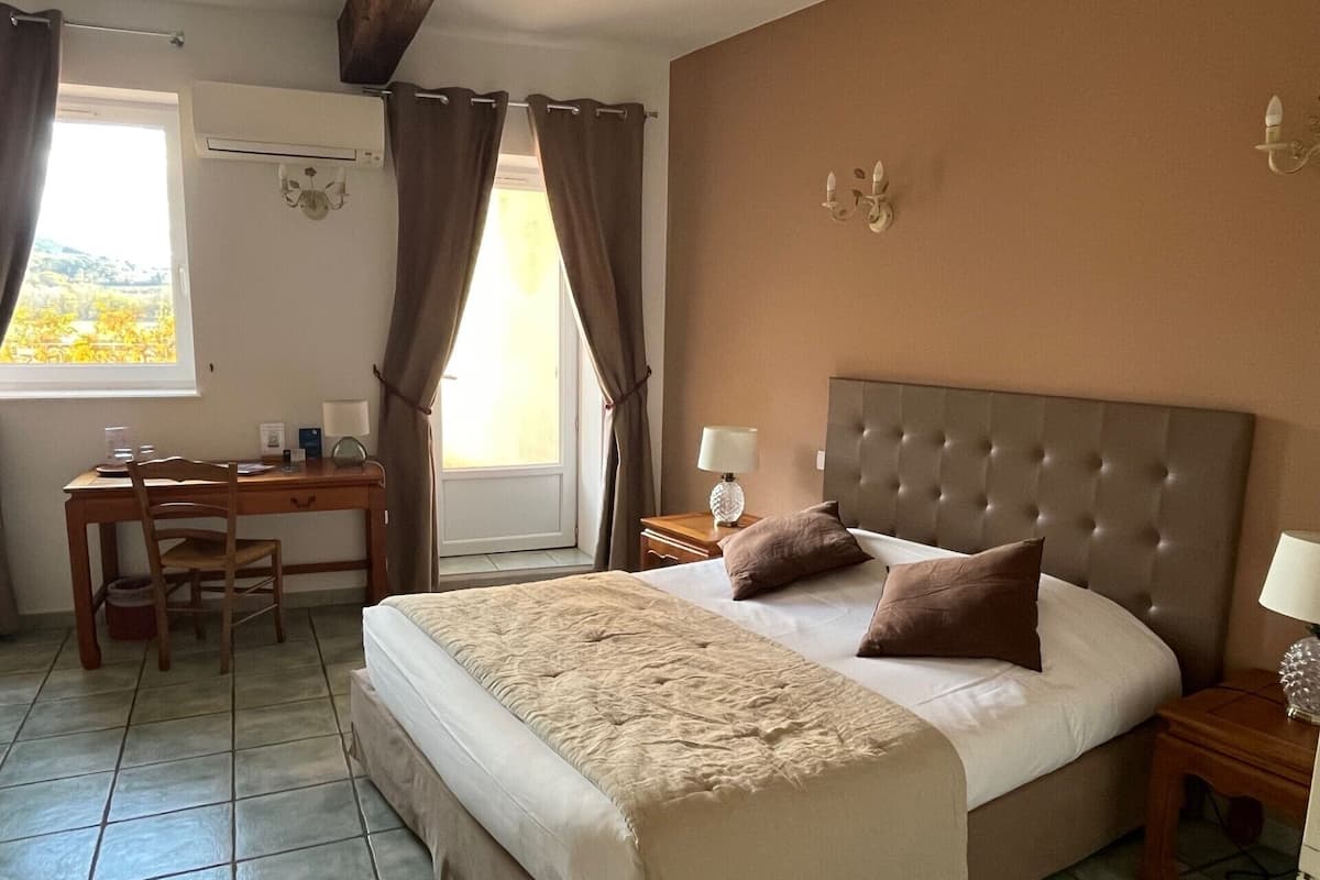 Een hotelkamer met een bed, bureau en stoel.