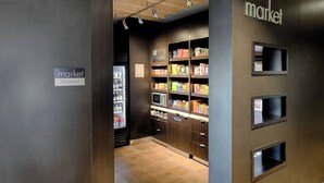 A modern interior with wooden cabinets and a refrigerated display. - Courtyard by Marriott Albany Clifton Park (Clifton Park)