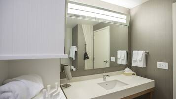 A modern bathroom with a large mirror, a sink, and a towel rack.