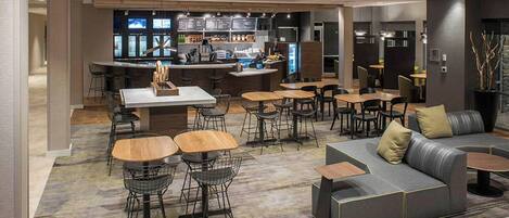 A modern hotel lobby with a bar area, seating arrangements, and a reception desk.