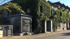 En traditionell byggnad med en skylt som visar att det är en restaurang, och restaurangens namn är "TRAITEUR". Här erbjuds ett varierat utbud av rätter.