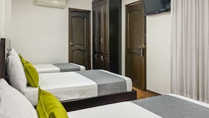 A hotel room with two beds, a wardrobe, a television, and a curtain. - Ayenda 1139 Castellón Plaza (Pereira)