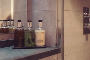 Three bottles of Cole & Lewis London body wash and conditioner on a bathroom counter.