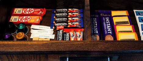 A drawer with various chocolate bars and instant coffee packs.