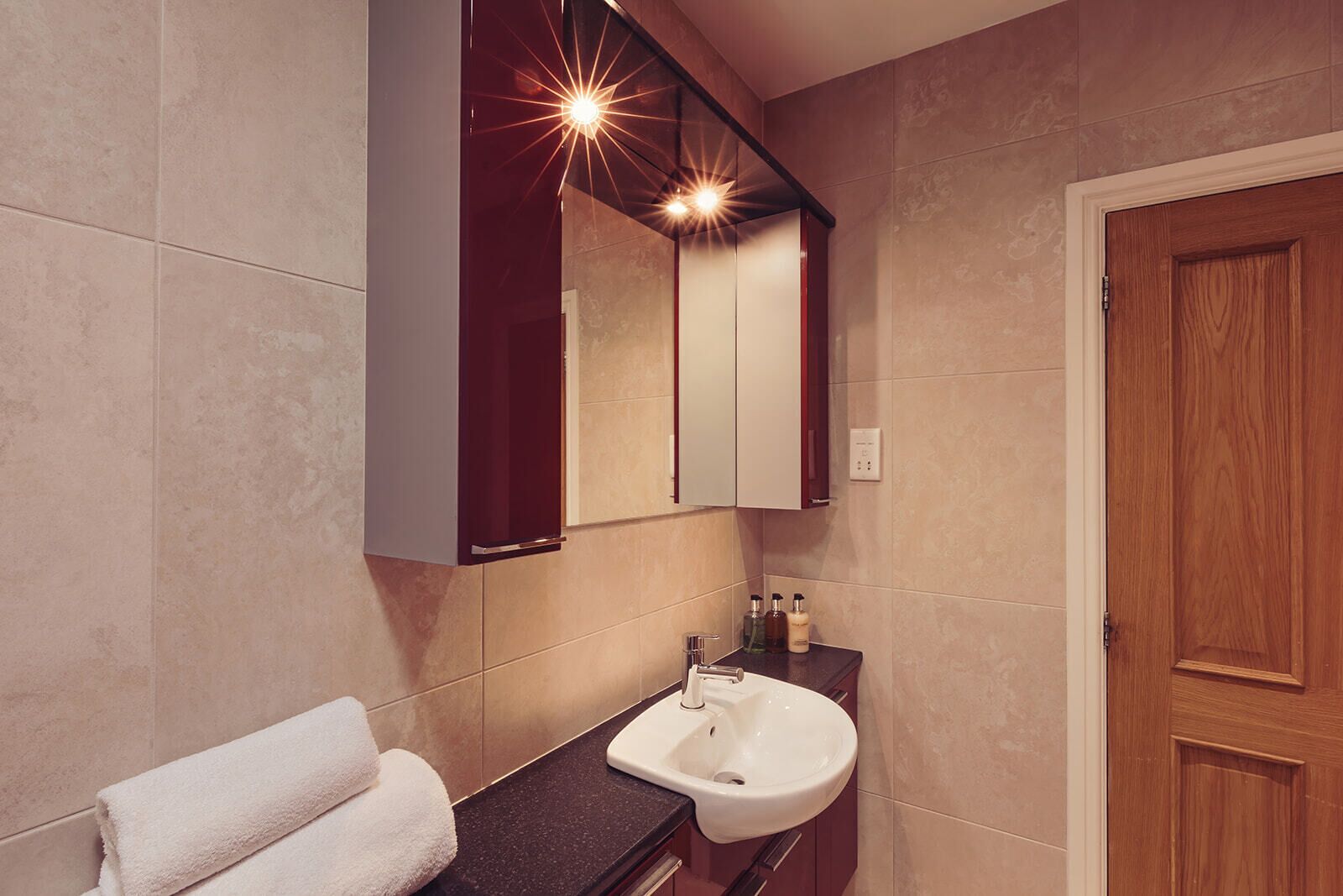 A modern bathroom with a vanity, sink, and mirror.