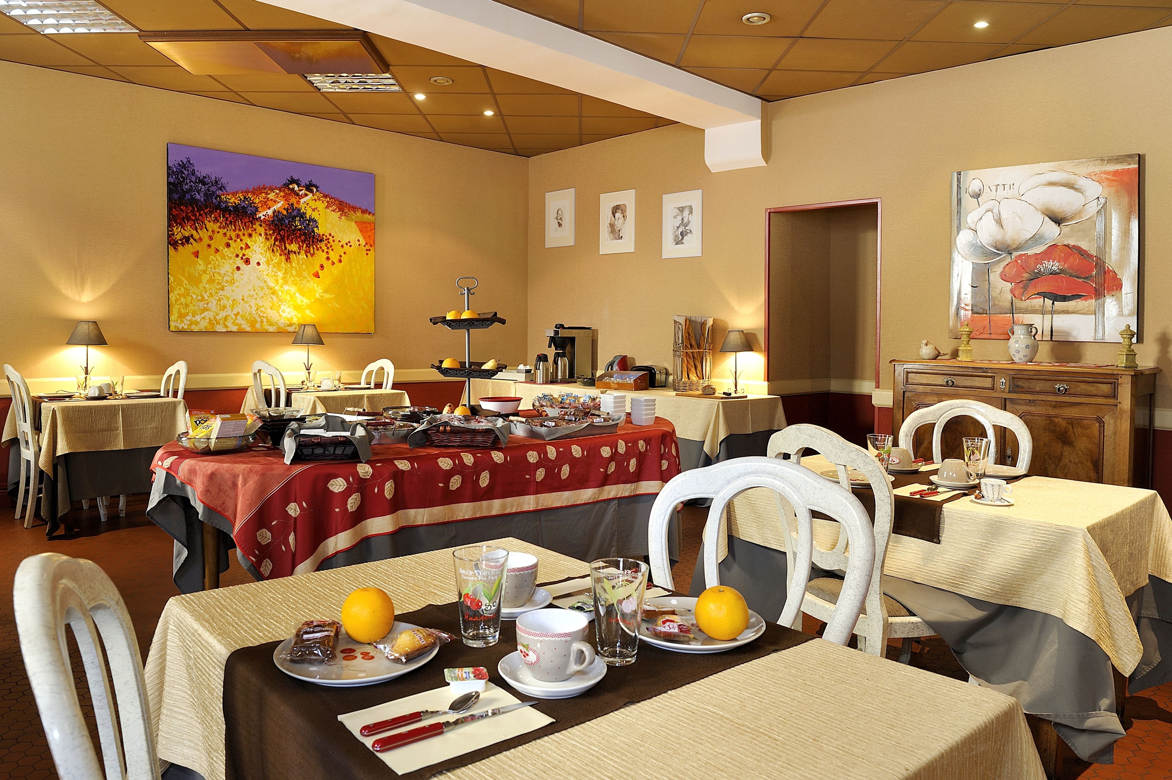 A dining area with tables set for breakfast, featuring various breakfast items and beverages.
