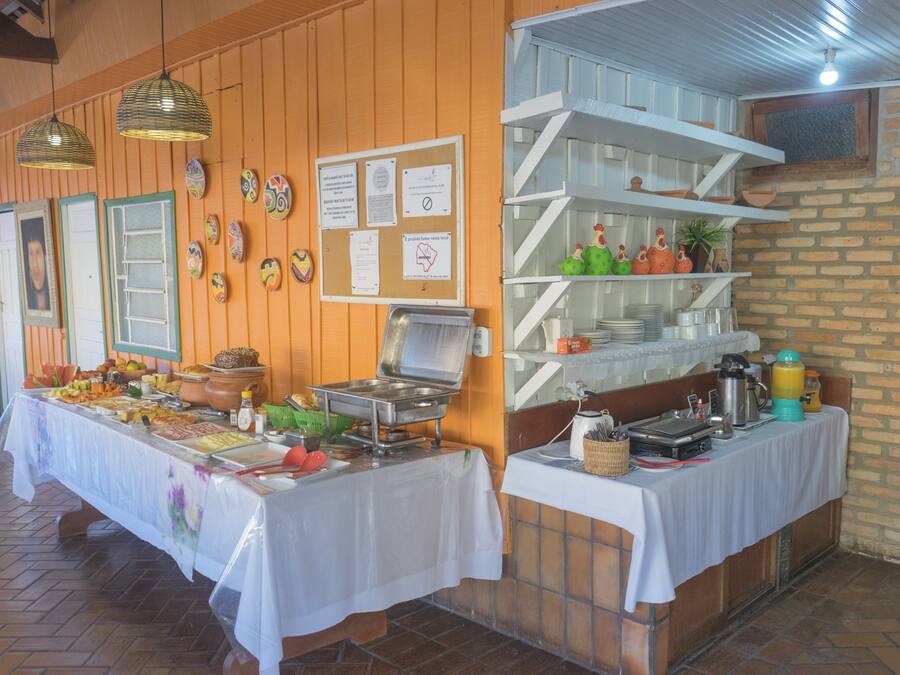 Montaje de bufé con múltiples estaciones de servicio, una variedad de alimentos y un interior rústico con paredes de madera y detalles de ladrillo.