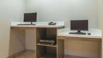 Two desks with computers, a printer, and a telephone.
