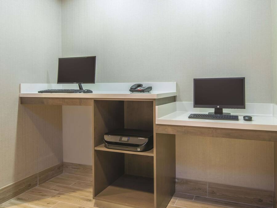 Two desks with computers, a printer, and a telephone.