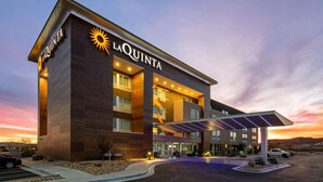 Un hotel de diseño moderno, con un llamativo letrero de 'LAQUINTA' y un acceso cubierto.