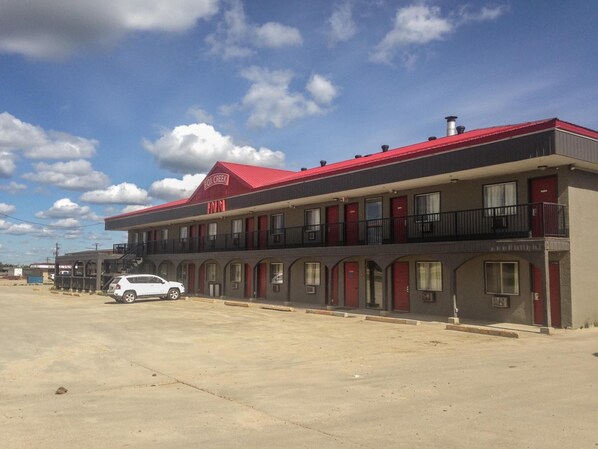 A two-story motel with a red roof and multiple balconies.