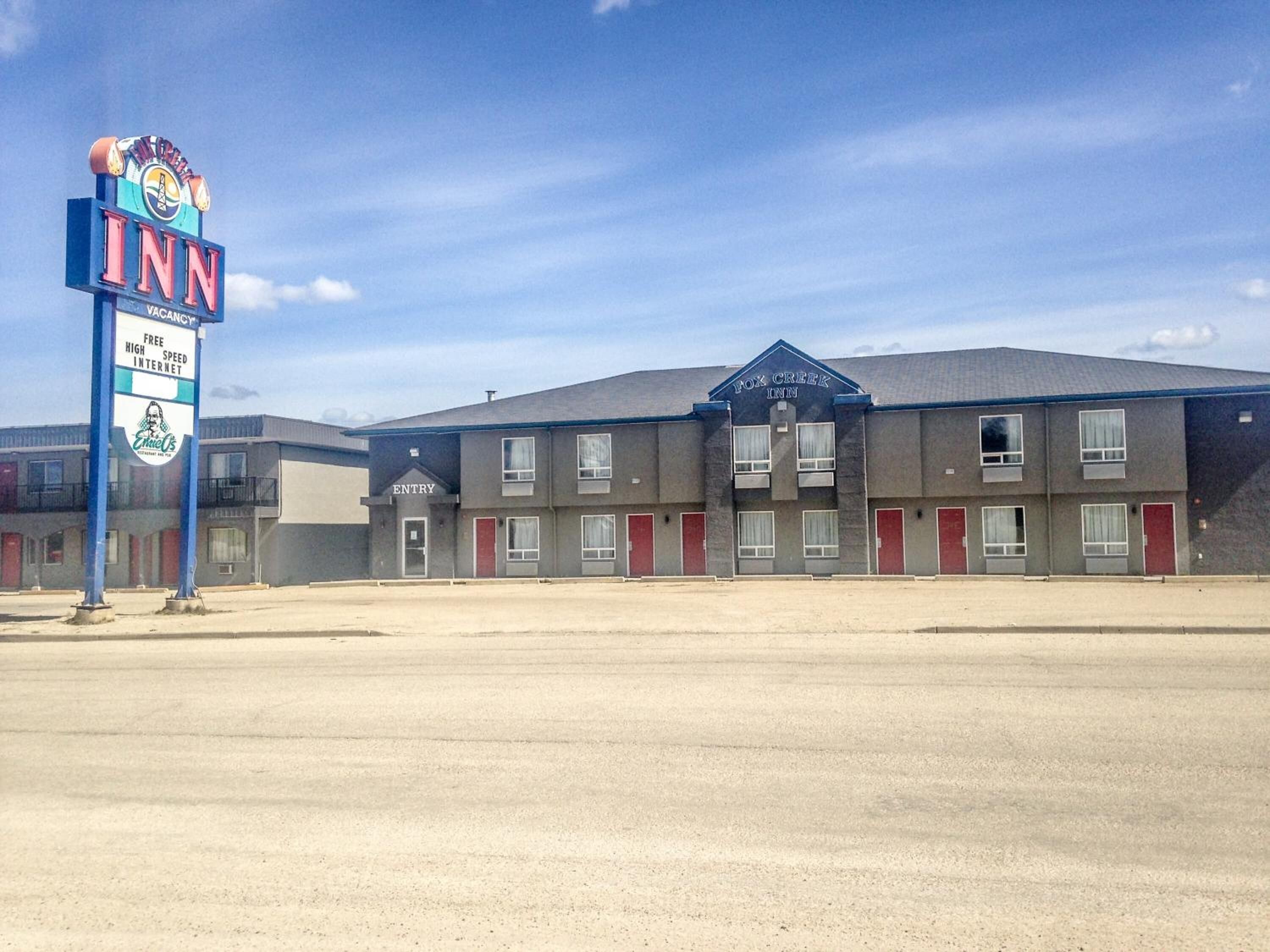 A Fox Creek Inn with a signboard advertising free high-speed internet and a vacant sign.