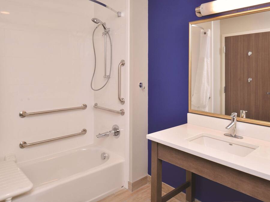 Une salle de bain avec une baignoire, une douche, un lavabo et un miroir.