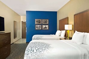 A hotel room with two beds, a television, a dresser, and a blue accent wall with framed pictures. - La Quinta Inn & Suites by Wyndham Page at Lake Powell (Page)
