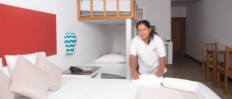 A hotel room with a bunk bed, a desk, and a chair.