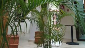 A multi-level atrium with wooden railings and potted plants. - Hotel Presidente (Las Tablas)
