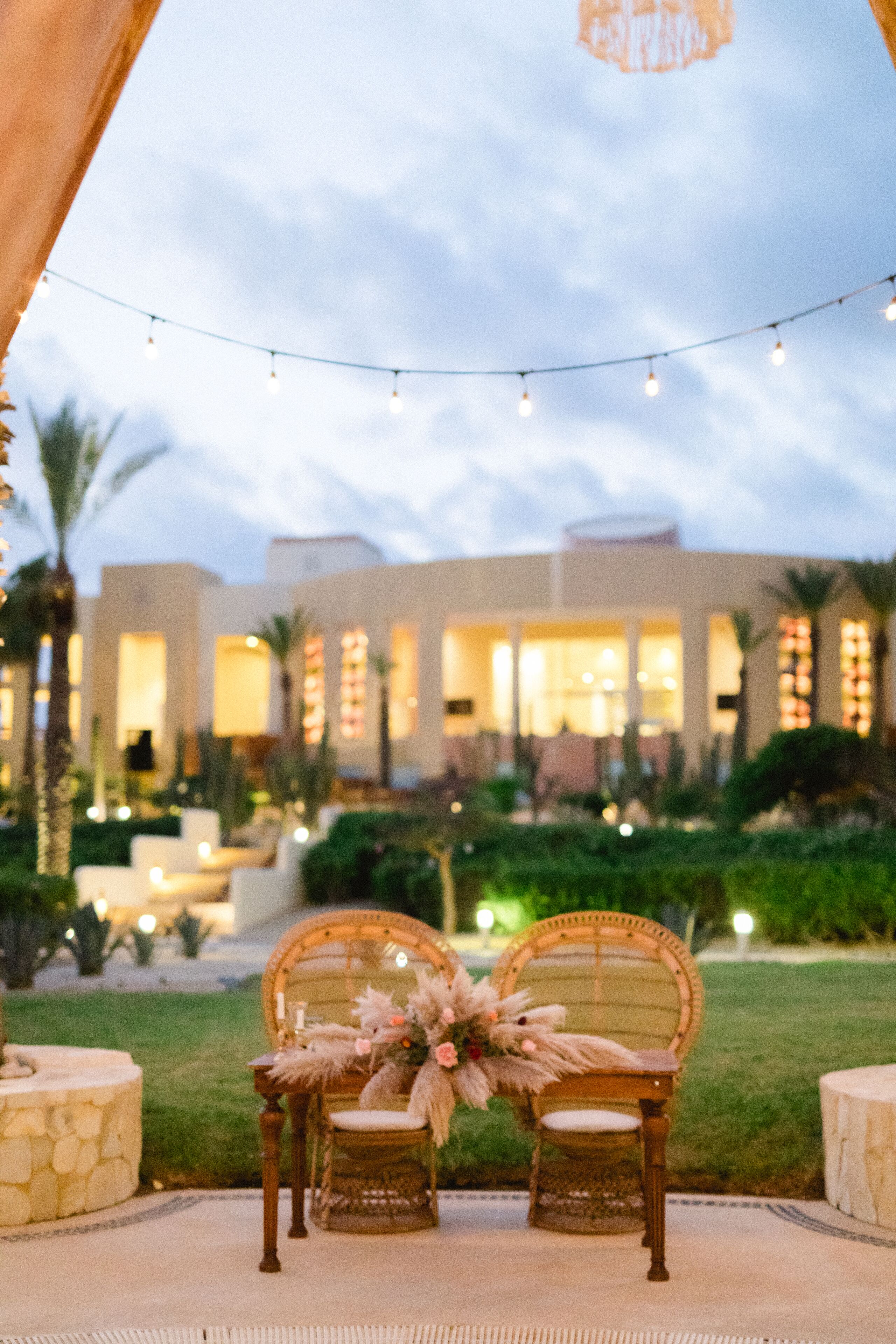 An outdoor seating area with two chairs, a table, and a decorative arrangement.