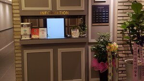 Una recepción con un ordenador, folletos informativos y una planta.